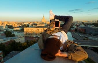 Person laying on a rooftop with mobile